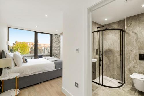伦敦Executive 1 & 2 Bed Apartments in heart of London FREE WIFI by City Stay Aparts London的一间卧室配有一张床和淋浴,还有一间浴室