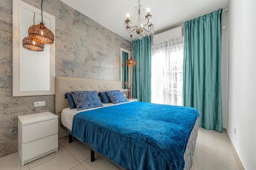 阿德耶Beautiful deluxe apartment Sun and Sea的一间卧室配有蓝色的床和绿色窗帘