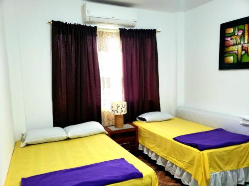 巴克里索莫雷诺港EMMA HOUSE的紫黄色间内的两张床