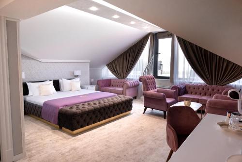 诺维萨德Queen Palace的酒店客房,配有一张床和一些椅子