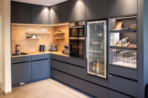辛根PRIMERA Apartments的厨房配有黑色橱柜和柜台。