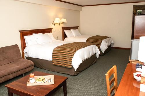 万卡约Hotel Presidente Huancayo - Asociado Casa Andina的酒店客房,设有两张床和一张沙发