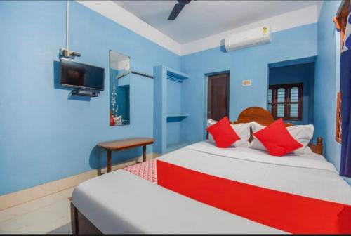 科纳卡Labanya Lodge的一间卧室设有两张床,墙上配有电视。
