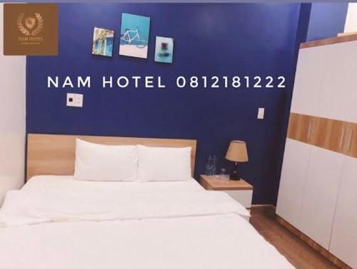 Bản CoKhach san Nam Hotel的一间卧室配有一张蓝色墙壁的床