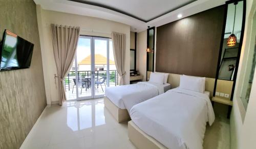 登巴萨Ultimate Residence Bali的酒店客房设有两张床和一个阳台。