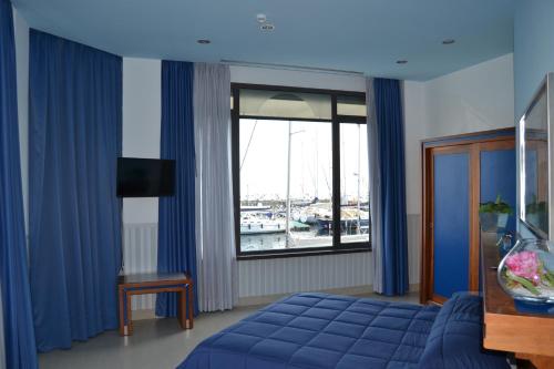 那不勒斯Transatlantico的一间卧室设有蓝色的床和窗户。