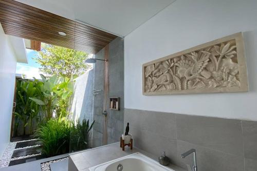 珀尼达岛Nau Nusa Villa的带浴缸的浴室和大窗户