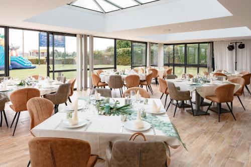 弗兰奎维尔-圣皮尔鲁昂庭院酒店的用餐室设有桌椅和窗户。