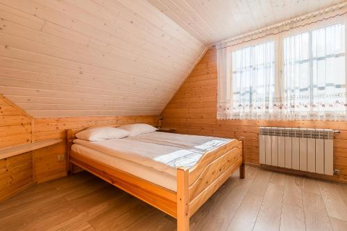 巴利格鲁德Domki Bystre的木制客房的一张床位,设有窗户