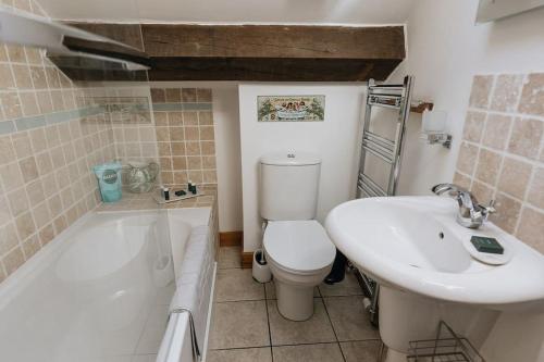 WirksworthFryers Cottage - Beautiful 2 bedroom Town & Country Cottage on edge of Peak District的浴室配有卫生间、盥洗盆和浴缸。