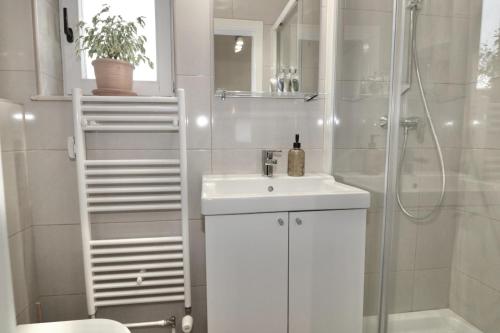 卢布尔雅那Studio City的白色的浴室设有水槽和淋浴。