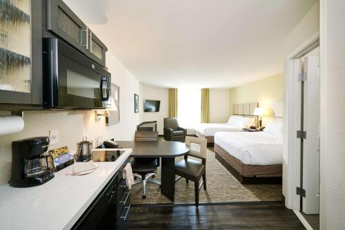 林夕昆高地Sonesta Simply Suites Baltimore BWI Airport的酒店客房设有厨房和卧室