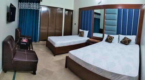 卡拉奇SUBHAN PALACE Near Lasania Restaurant & Millennium Mall的酒店客房,配有两张床和椅子