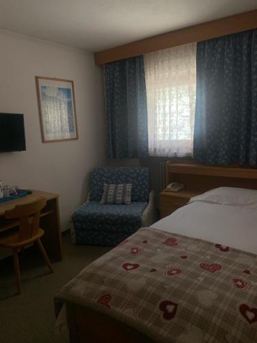 布勒伊-切尔维尼亚西姆逼安切酒店的配有一张床和一把椅子的酒店客房