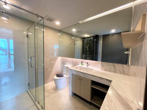 苏林海滩Panora Deluxe sea view apartment by Lofty的一间带水槽和玻璃淋浴的浴室