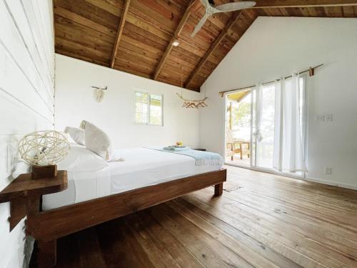 博卡斯德尔托罗Bird Island Bungalows的一间卧室配有一张床,铺有木地板