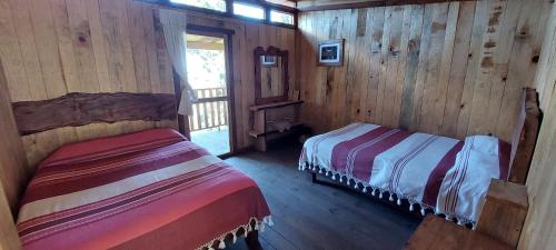 El PacíficoCabaña en el Bosque de San José del Pacífico的小木屋内一间卧室,配有两张床