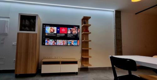 萨拉曼卡Asturin House - PARKING GRATIS的一间设有桌子和墙上电视的房间