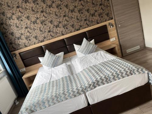 纽伦堡Hotel LACIN的一间卧室配有一张大床、床头板和枕头