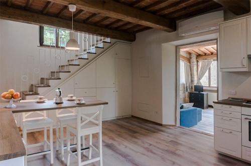 CapannucciaFAETOLE typical Tuscan country house near FLORENCE的房屋内的厨房,配有桌子和楼梯