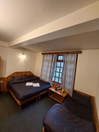 马拉里Mars Monkey Hostel & Cafe的一间卧室设有两张床和窗户。