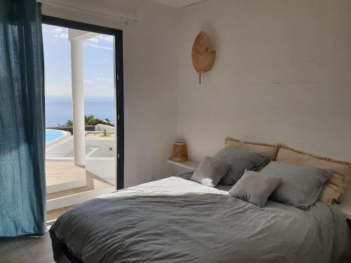 圣勒Villa romantique, Rêve d'ailleurs, saint leu, la Réunion的一间卧室设有一张床,享有海景