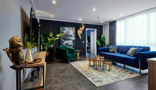 明斯特MARRAM Suitehotel的客厅配有蓝色沙发和一些植物