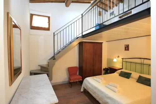 圣吉米纳诺圣吉米纳诺法比奥公寓的一间卧室设有一张床和一个楼梯
