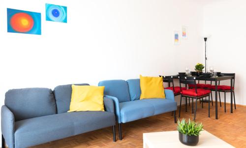 维也纳Pal's Favoriten Apartment的客厅配有蓝色的沙发和桌子