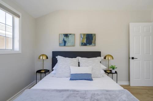 洛杉矶New 5 bed w/hot tub close to Universal sleeps 12的一间卧室配有一张带两盏灯的大型白色床。
