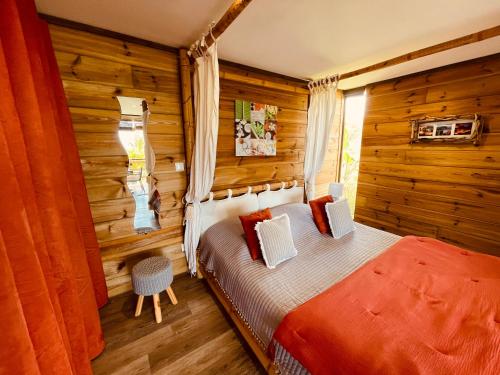厄唐萨雷Gîte Paradis Lé La的卧室配有一张床铺,位于带木墙的房间内