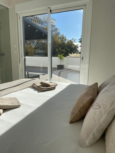 马贝拉Marbella Centre with terrace and pool的配有枕头的白色床和大窗户