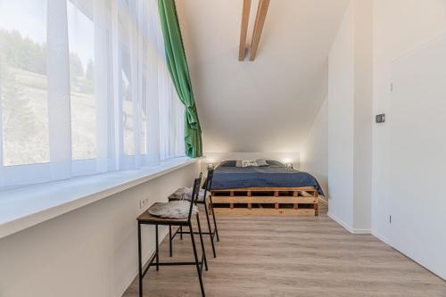 兹蒂尔Chata Zdiarka 4M的卧室配有一张床和一张桌子及椅子