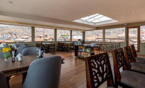 库斯科Tikala Cusco Boutique Hotel的餐厅设有桌椅和窗户。