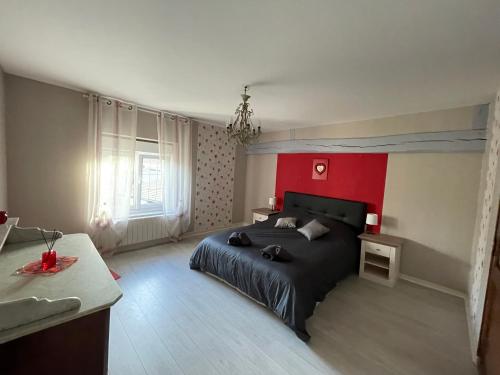 AthisGîte le Calyaden的一间卧室设有一张黑色的床和红色的墙壁