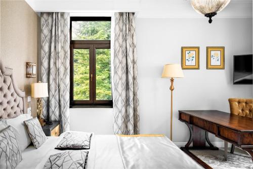 伯伊莱海尔库拉内Hotel Versay的一间卧室配有一张床、一张书桌和一个窗户。