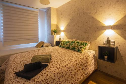 卡塔赫纳CARTAGENAFLATS, Apartamentos Anfiteatro Romano 4B的一间卧室配有一张带绿色枕头的床和一扇窗户