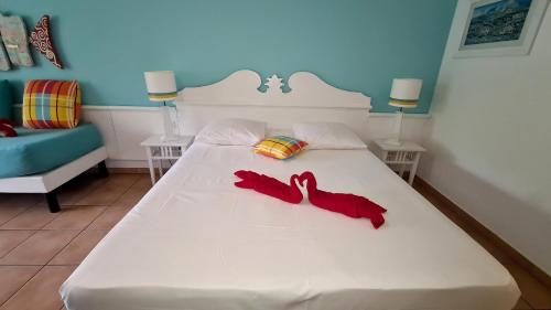 圣吕斯Studio Premium Vue Mer, Plage的卧室配有白色的床和红色鞋