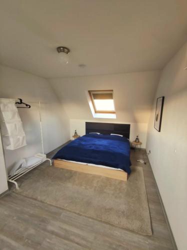 门登Dachgeschosswohnung mit Klimaanlage in bester Lage的一间卧室配有一张带蓝色棉被的床