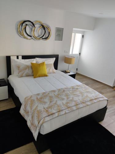 圣罗克杜皮库Casa da Avó Biza的卧室配有一张带黄色枕头的大型白色床。