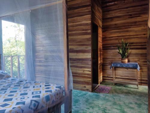 帕洛米诺Hostal Corazón de Tagua的卧室设有木墙、一张床和窗户