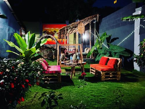 阿鲁沙Serengeti Villa的一个带两把椅子的花园和一个坐在秋千上的人