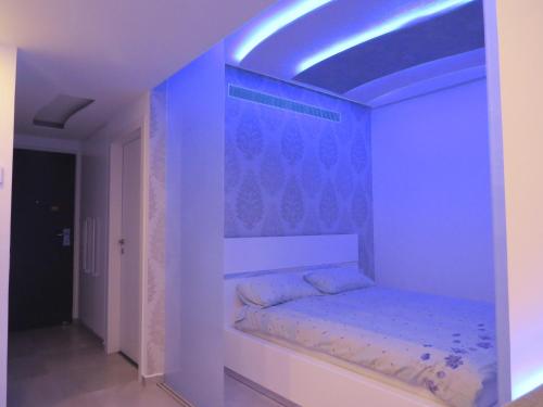 巴特亚姆Apartment Ben Gurion的蓝色灯光客房内的一张床位