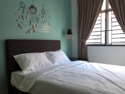 Bandar PenawarComfortable House w AC 4 Bedrooms WIFI PS4 near Desaru Beach的一间卧室配有一张带白色床单的床和一扇窗户。