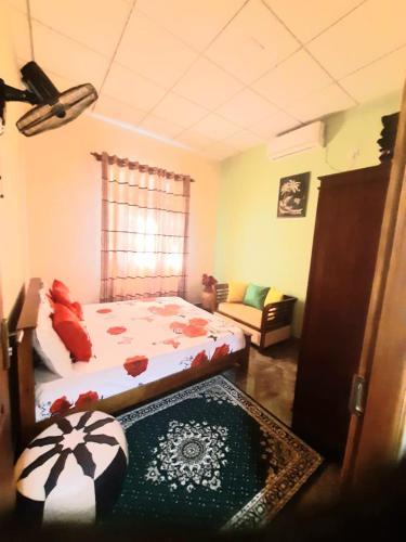 TalagalaHappy Nest的一间卧室配有一张床和一张沙发