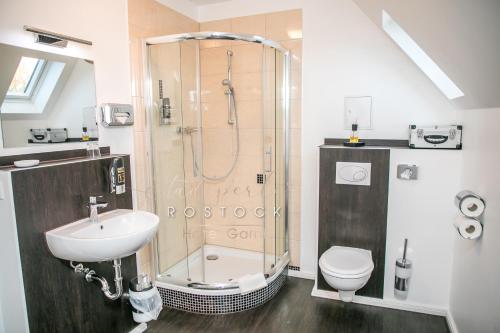 罗斯托克洛斯托克斯达特皮尔酒店的带淋浴、盥洗盆和卫生间的浴室