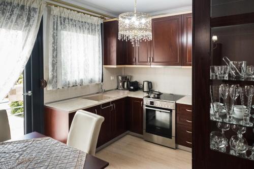 韦里亚Luxury Dafnis House的厨房配有木制橱柜和吊灯。