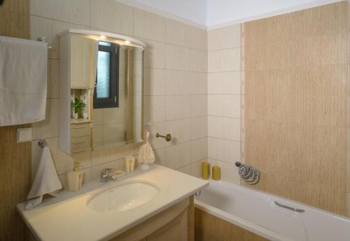 韦里亚Luxury Dafnis House的一间带水槽、浴缸和镜子的浴室