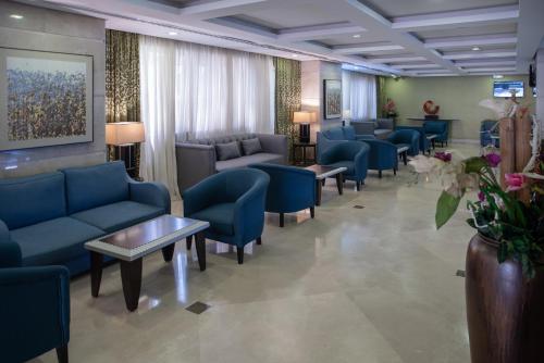 麦加阿尔基斯瓦大厦酒店的一间配备有蓝色沙发和椅子的等候室