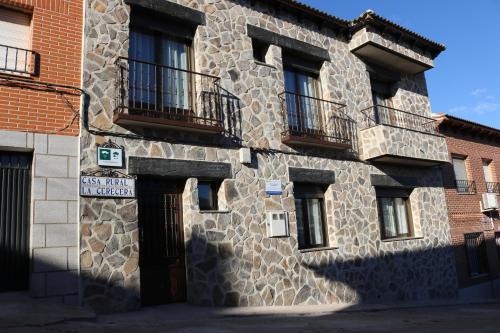 Los NavalucillosCasa Rural "La Cerecera"的一座石头建筑,旁边设有阳台